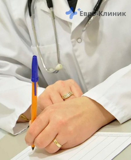 доктор в белом халате сидит за столом