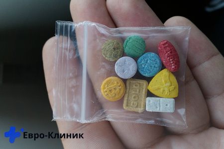 В руке пакетик с таблетками наркотиками